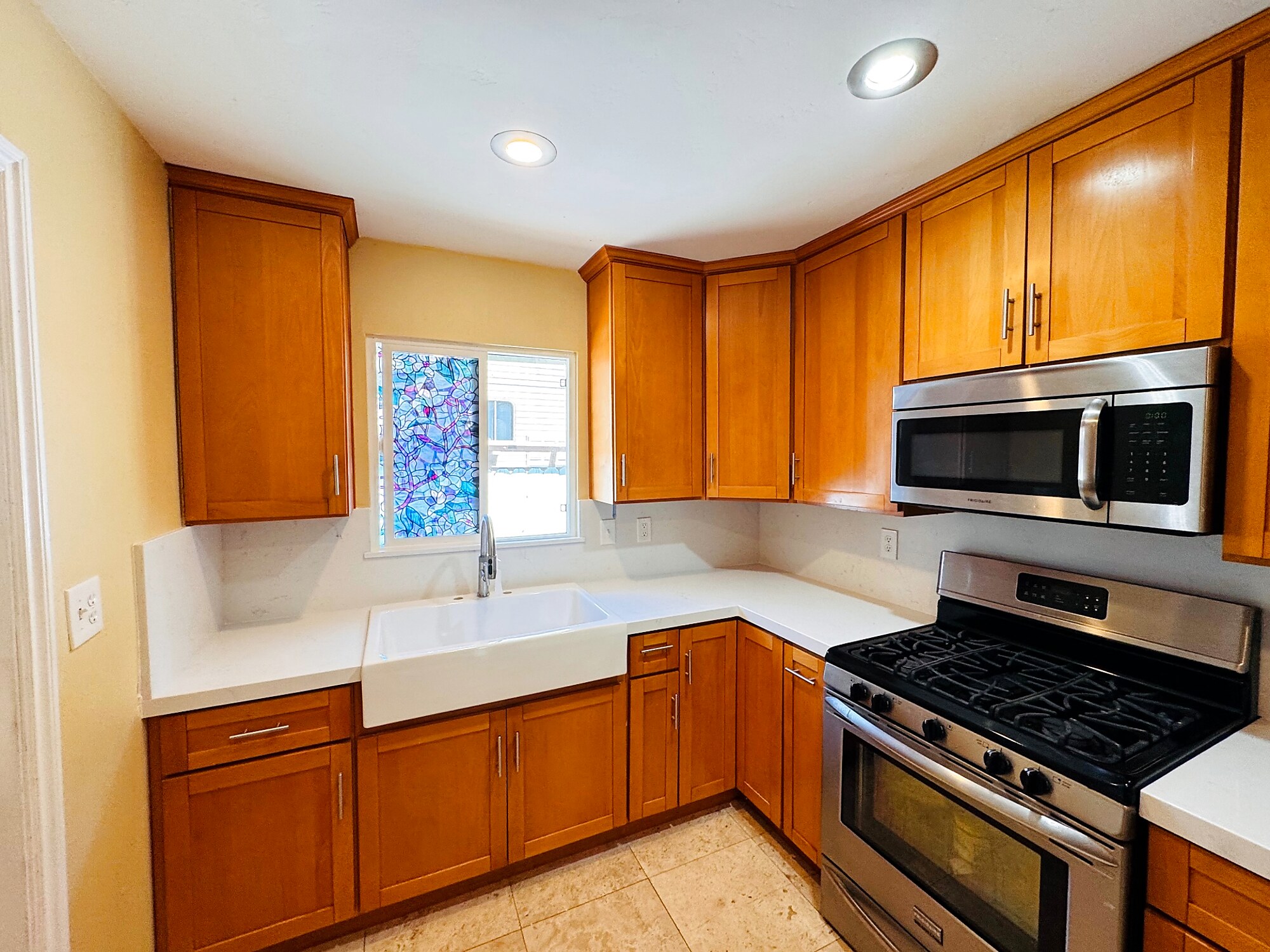 Cherry wood shaker cabinets with white quartz counters and farmhouse sink